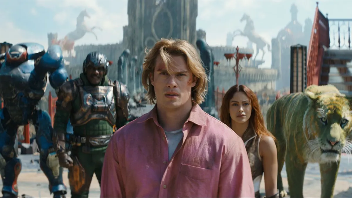 A cinematic still from the Masters of the Universe film showing the protagonist in armor against a desolate landscape.