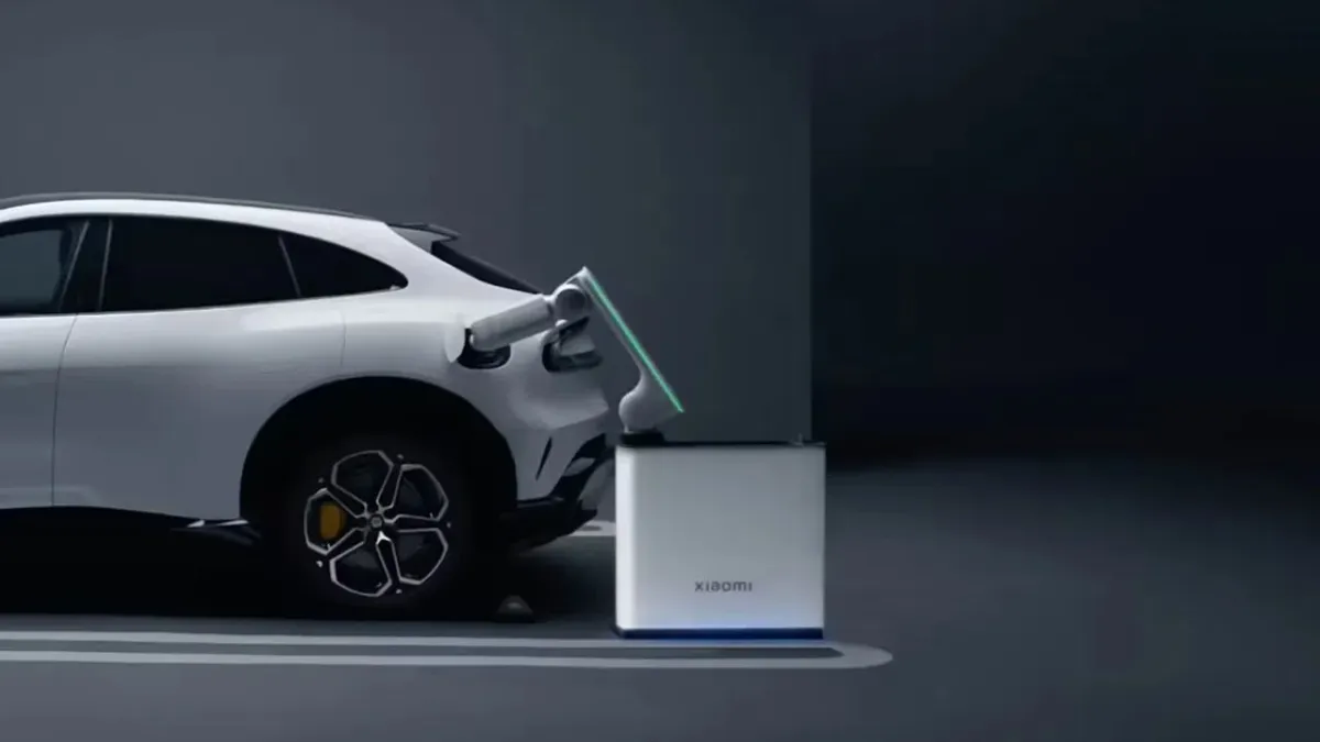 Compact robotic charging arm automatically connecting to an electric vehicle in a residential garage.