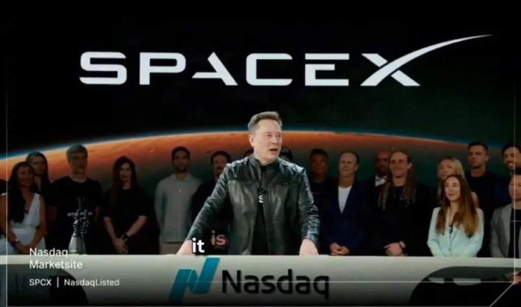 Elon Musk speaks at a podium during a SpaceX corporate event.