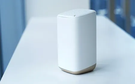 A white Xfinity wireless router sits on a wooden desk.