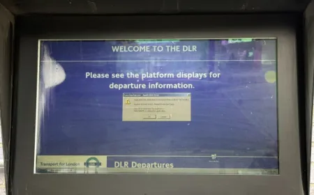 A vintage Windows error message appears on a Docklands Light Railway information screen at Limehouse station.