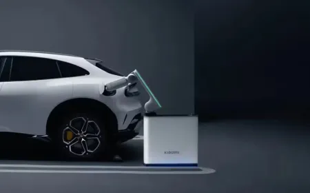 Compact robotic charging arm automatically connecting to an electric vehicle in a residential garage.