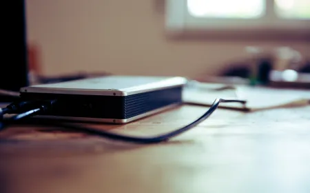 A lineup of portable external hard drives and solid state drives rests on a clean desk surface.