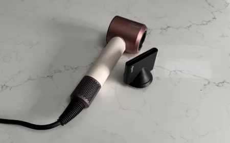 Dyson Supersonic Travel hair dryer in a compact silver design with an attached concentrator nozzle.