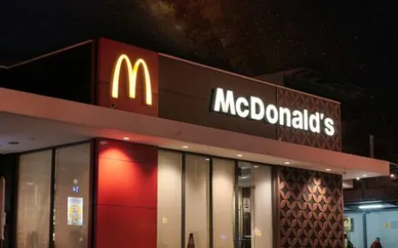 A McDonald's drive-thru lane with a voice ordering speaker and a waiting vehicle.