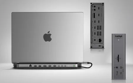 A Thunderbolt docking station connects to a MacBook with dual monitors and peripheral cables.
