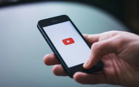 A teenager uses a smartphone displaying social media applications next to age restriction warnings.