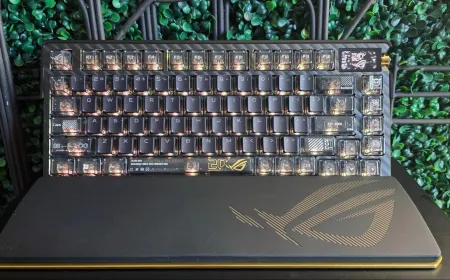Asus ROG Azoth Extreme Edition 20 keyboard featuring gold accents, transparent keycaps, an OLED screen, and a wrist rest.