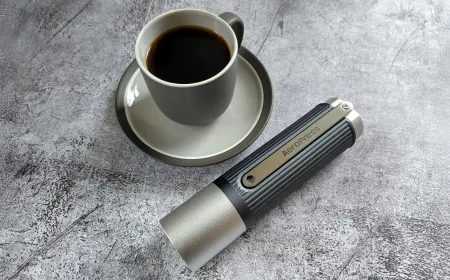 The AeroPress manual coffee grinder is shown in a close-up view highlighting its portable design.