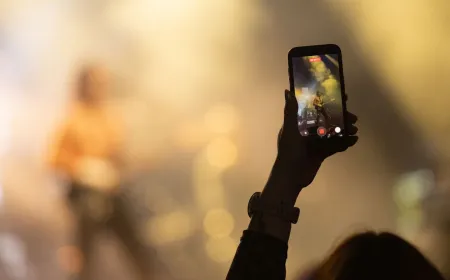 Audience members securing phones in locked pouches before a Phoebe Bridgers concert enforcing a phone-free policy.