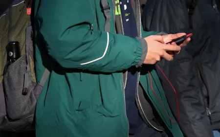 Teenagers check social media applications on their phones inside a classroom.