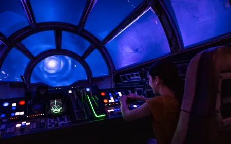 This screenshot shows the updated Millennium Falcon Smugglers Run attraction featuring The Mandalorian and Grogu.