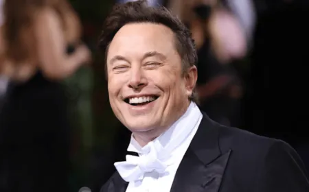 Elon Musk stands beside a SpaceX logo display during his historic trillionaire milestone announcement.