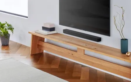 A compact soundbar features visible bass reflex ports to enhance low-frequency audio response.