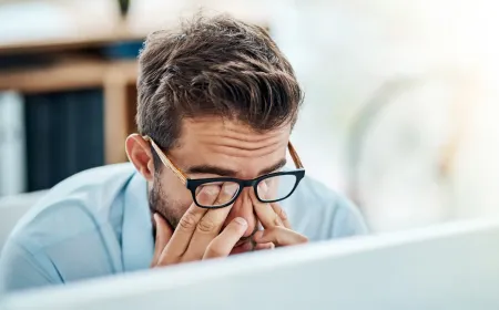 A desk worker maintains proper posture at an ergonomic workstation with a monitor.