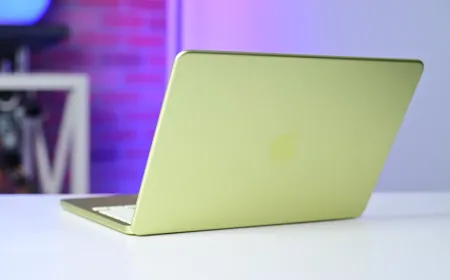 A silver MacBook Neo laptop sits open on a desk.