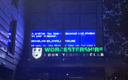 A Windows halt screen displays on a public digital sign at a historic cricket club during a driver power failure.