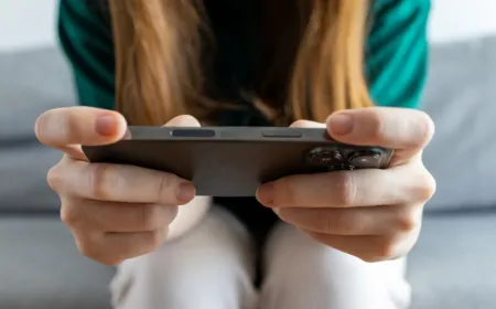 A teenager holds a smartphone next to a digital clock showing proposed UK social media age limits.