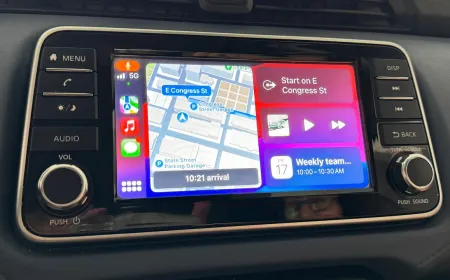 A vehicle dashboard screen displays the Apple CarPlay interface while a video streaming application runs.