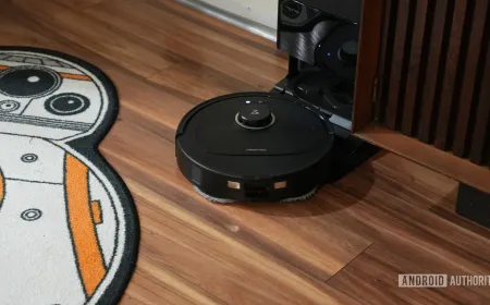 Roborock Qrevo S5V robot vacuum and mop beside its docking station with dual spinning mops and water refilling system
