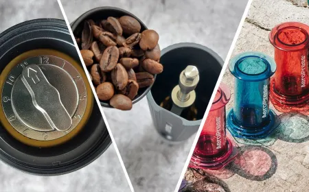The AeroPress manual coffee brewer rests on a countertop with its filter cap and plunger attached.