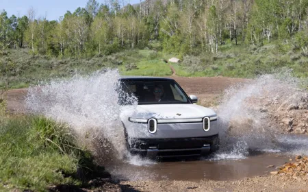 The 2027 Rivian R2 electric crossover is parked on a paved road.