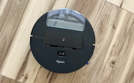 A robot vacuum cleaner navigates a hardwood floor in a residential room.